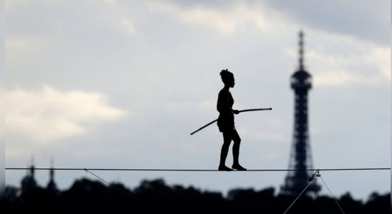 Tightrope walker crosses river 